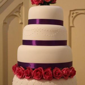 Fuchsia pink roses and purple wedding cake